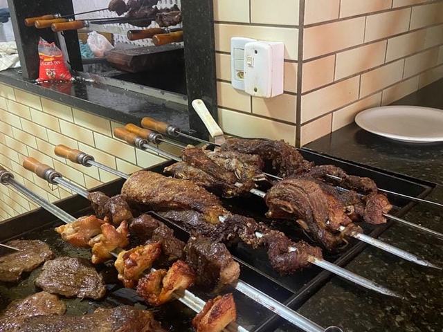 Espetos de carnes grelhadas na grade do restaurante.