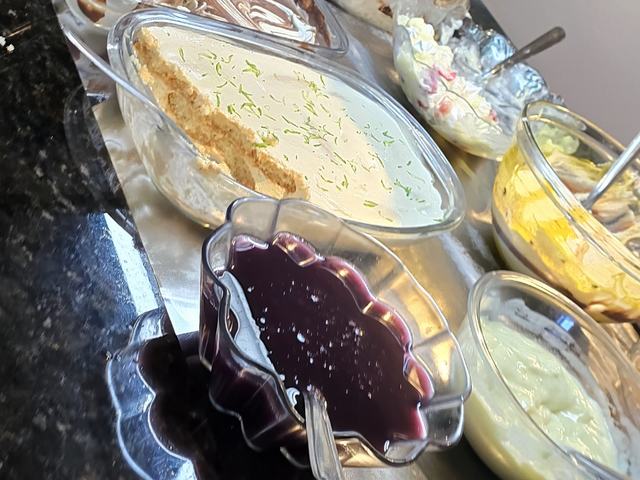 Mesa de sobremesas do buffet: torta de limão, mousse de chocolate e geleia.